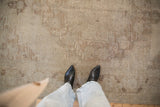 The worn, hand-knotted texture and visible knot heads of a distressed Oushak carpet.