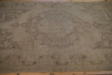 Close view of the distressed Oushak's hand-knotted texture and wear to the foundation.