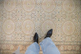Personal perspective of the distressed low-pile texture on a vintage Kaisary rug with roundel medallions.
