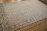 The hand-knotted texture and stylized floral vine border of a distressed Kaisary rug.