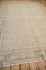 Angled view of a vintage Kaisary carpet highlighting its evenly worn pile and repeating roundel medallions.