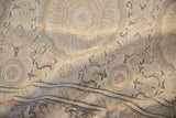 Angled view of a distressed Kaisary carpet's soft pile, showing even wear and dusty rose motifs.