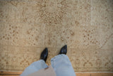 The softly worn texture and neutral tones of a distressed Kaisary carpet viewed underfoot for scale.