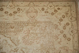 Corner of a distressed Turkish Kaisary rug showing pale blossoms and soft, low-pile texture.