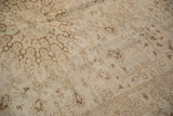 Textured, low pile of a distressed Kaisary rug with expressive pale brown floral vine patterns.