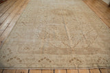 Vintage distressed Kaisary carpet viewed from a long angle, showcasing its sprawling vines in pale coffee tones.