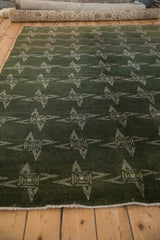 Repeating ivory starburst pinwheel motifs and texture on a Mallard green vintage Sparta rug.