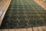 Vintage Sparta rug's abstract pinwheel pattern, with pointed fins in mallard green and ivory.