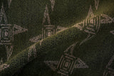 Close-up of vintage Sparta carpet's textured mallard green pile with abstract pinwheel motif.