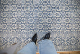 A close view of the soft, plush pile and stylized tree of life motifs in slate blue.