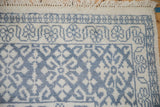 A plush corner of a vintage Agra carpet with a slate blue border and ivory fringe.
