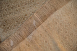 Worn cream and coffee brown pile of a distressed Kars rug, revealing its hand knotted foundation.