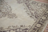 Distressed Oushak rug's texture with faded platinum field and geometric brown patterns.