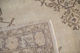 Distressed pile and hand-knotted reverse of the vintage Oushak rug corner.