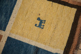 Hand-knotted texture and dusty sapphire human figure motif on a pale saffron Gabbeh panel.