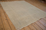 Side angle view of the distressed Oushak rug, detailing its textured, time-softened surface.
