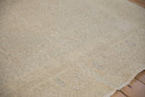 A close view of the distressed Oushak's textured weave showing wear to the knot heads.