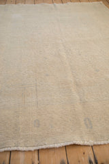 Angled view showcasing the worn, low-pile texture of the distressed vintage Oushak carpet.