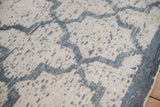 Low pile and visible weave of a distressed Indian carpet with a blue lattice design.