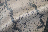 Close-up of the textured, silk-like mercerized cotton pile on a distressed Indian carpet.