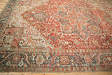 Distressed vintage Heriz carpet with worn cherry red pile and slate blue serrated leaf border.