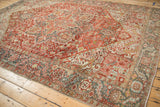 Distressed vintage Heriz rug corner, featuring serrated leaf palmette border and time-softened hues.