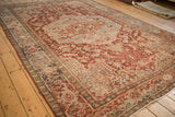 Distressed Heriz carpet corner, revealing Samovar Turtle motif border in red, ivory, dusty teal.