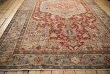 Distressed Heriz carpet: dusty teal border with Samovar Turtle motif, brick red field, worn fringe.