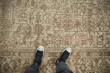 Geometric vines and low-pile texture of a distressed vintage Mehrivan rug in sand and dusty teal.