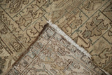 The hand-knotted foundation and worn pile of a vintage distressed Mehrivan carpet corner.