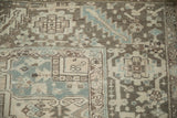Distressed Heriz carpet detail: geometric blossoms, serrated vine border, even wear.