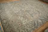 Distressed vintage Persian Heriz rug detail: shield medallion, geometric blossoms, beige and blue.