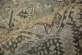Distressed Heriz rug texture, showing geometric patterns in sand and pale slate blue.