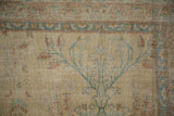 Distressed antique Persian Yezd carpet close-up, showing pale gold, blue, and copper bouquet motif.