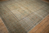 Distressed antique Yezd rug corner, revealing wide banded border and delicate floral motifs.