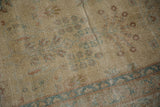 Distressed antique Yezd carpet detail: delicate floral bouquet, dusty tones, and visible foundation from wear.