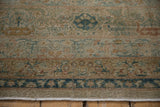 Distressed antique Yezd carpet's worn pile, showing pale gold, blue, and copper blossom motifs.