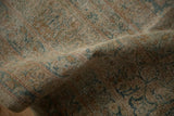 Textured pile of antique distressed Yezd carpet, showcasing worn floral motifs in dusty gold and blue.