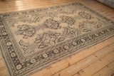 Main border of dark brown floral and germinating plant motifs on a distressed Oushak carpet.