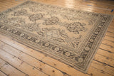 Distressed vintage Oushak rug corner with dark brown germinating plant main border.