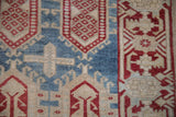 Distressed vintage Oushak runner pile, with geometric cartouches in sky blue, cherry red, and sand.