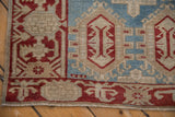 Distressed Oushak runner pile, cherry red vine border, sky blue field, and stylized cartouche.