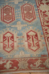 Distressed Oushak rug detail: cherry red cartouches, aquatic blue field, and even low pile.