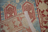 Vintage Oushak runner fold, exposing sky blue, red geometric pattern and hand-knotted foundation.