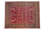 Antique Yezd carpet with a distressed raspberry field, floral vines, and jade green border.