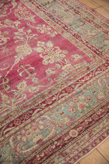 European-influenced floral border in jade green on a raspberry magenta antique Persian carpet.