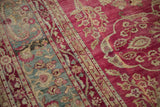 Antique Yezd carpet's raspberry field and jade green border with delicate floral sprays.