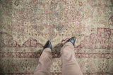 Mostly even wear on a distressed antique Kerman carpet, showing a low pile and raspberry floral details.