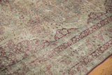 Low, worn pile of an antique Kerman carpet showing raspberry floral details and visible foundation.