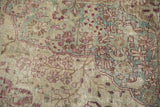 Worn pile of a distressed Kerman carpet showing knot heads and the underlying foundation.